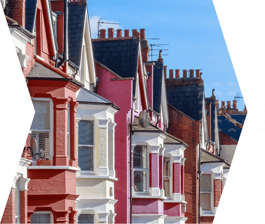 This image shows a row of Edwardian houses, all painted different colours, with a blue sky in the background.