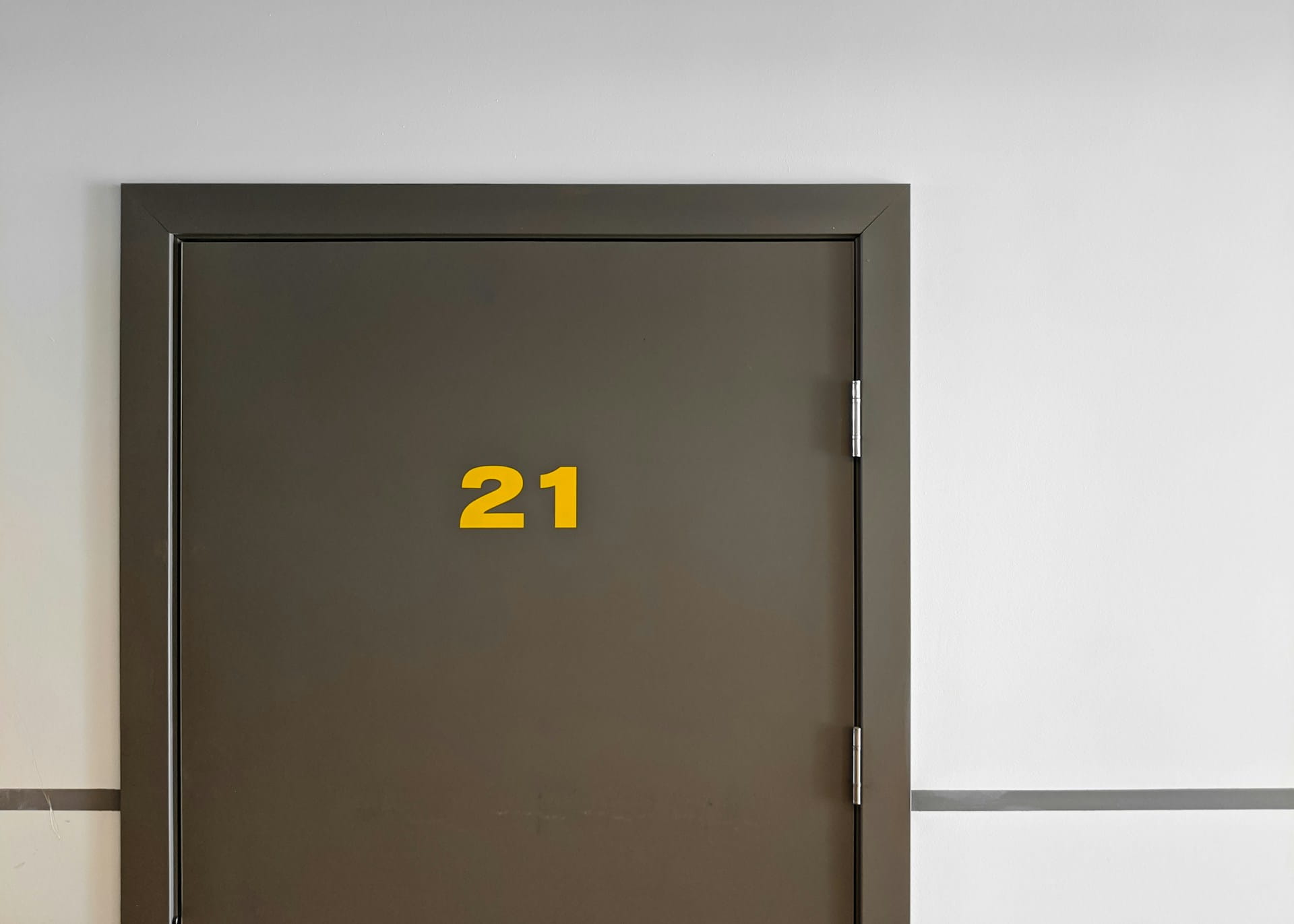 A door of a landlord's property with the number "21" displayed in yellow font on the front.