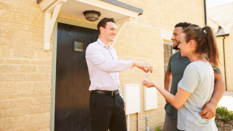 A live-in landlord handing a set of keys to his new tenants