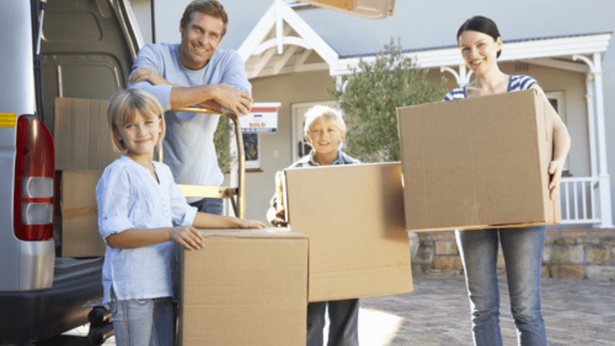 A family of 4 moving into their new rental property, they are all holding boxes.