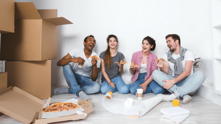 Four tenants eating pizza as they unpack 