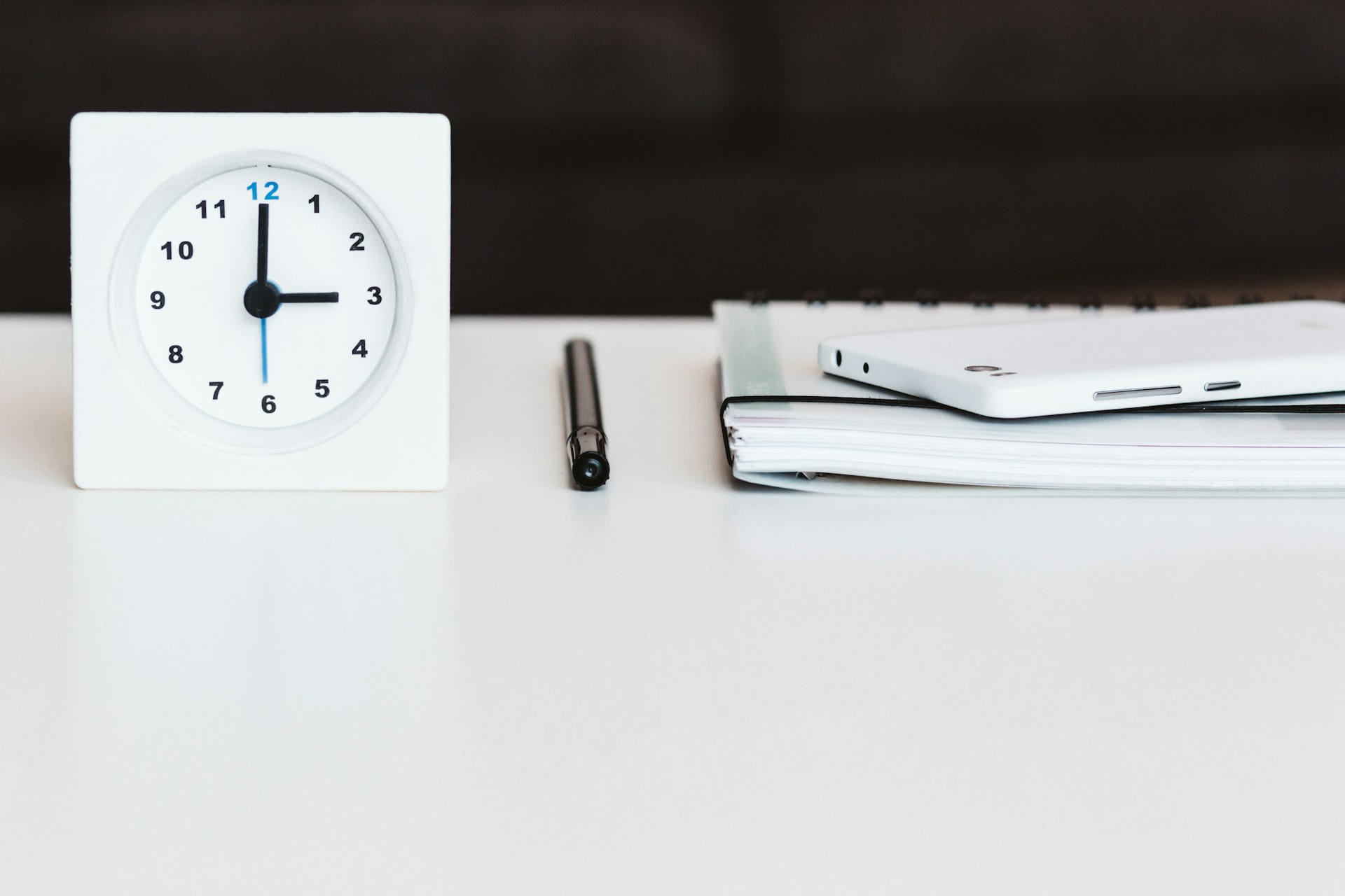 A clock on a table next to tenant referencing paperwork.