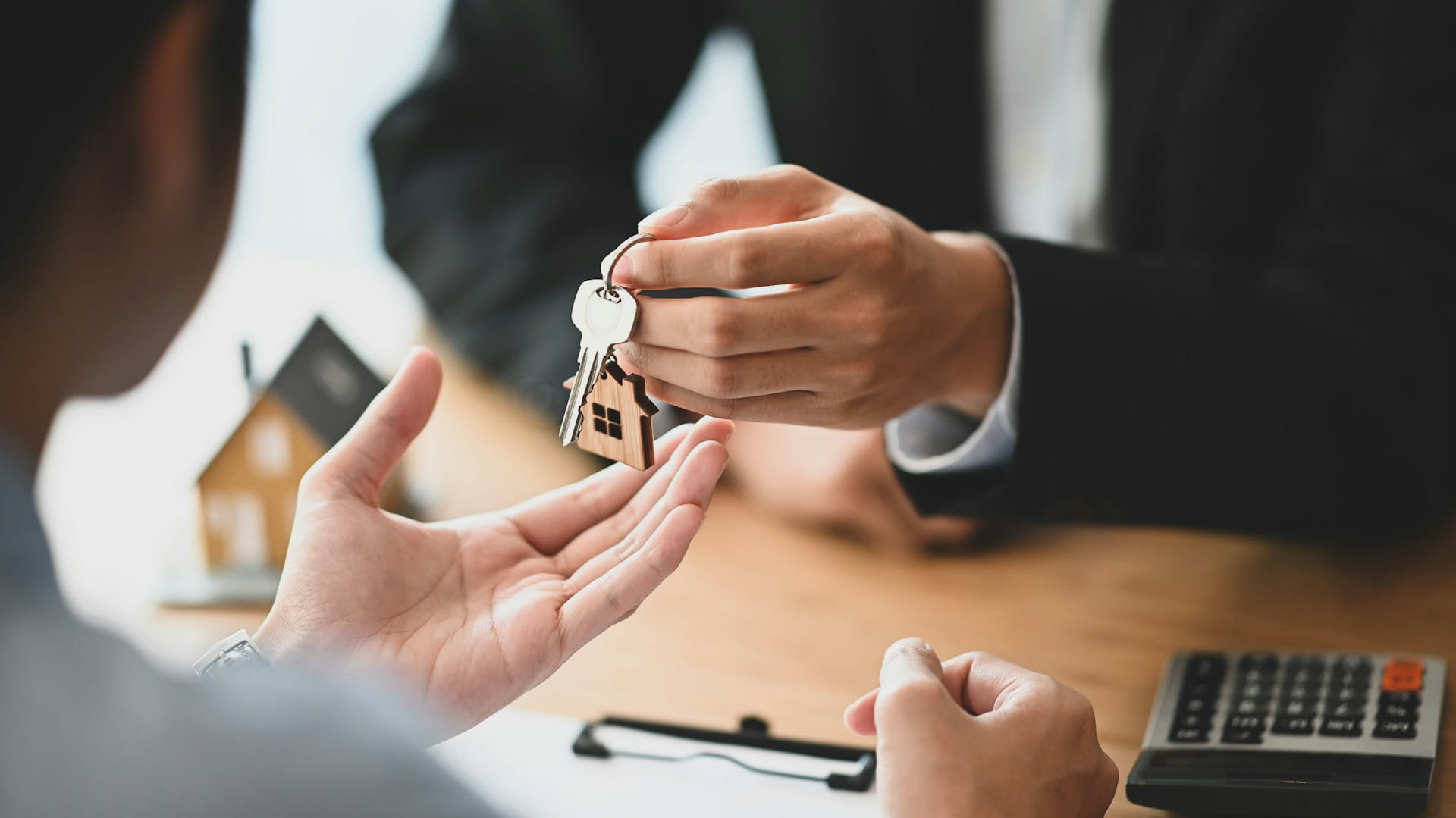 An estate agent handing over a set of keys to a recently referenced tenant